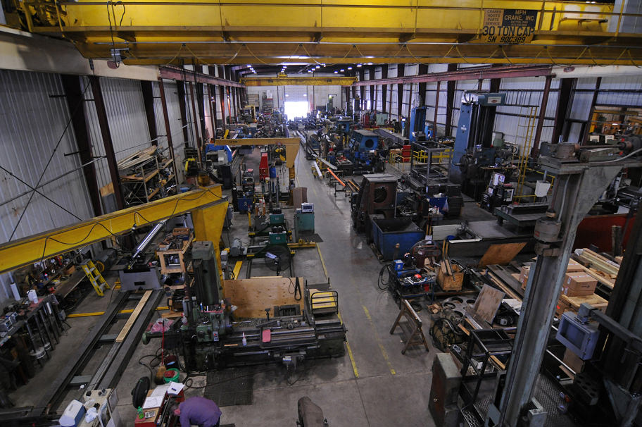 A high shot looking over workers and machines in another part of the shop
